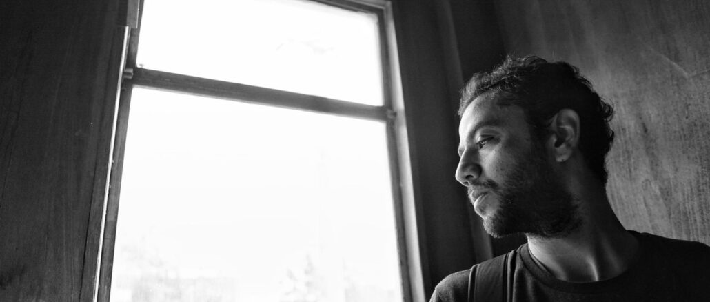 Person am Fenster im weichen Gegenlicht