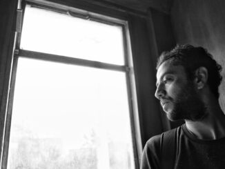 Person am Fenster im weichen Gegenlicht